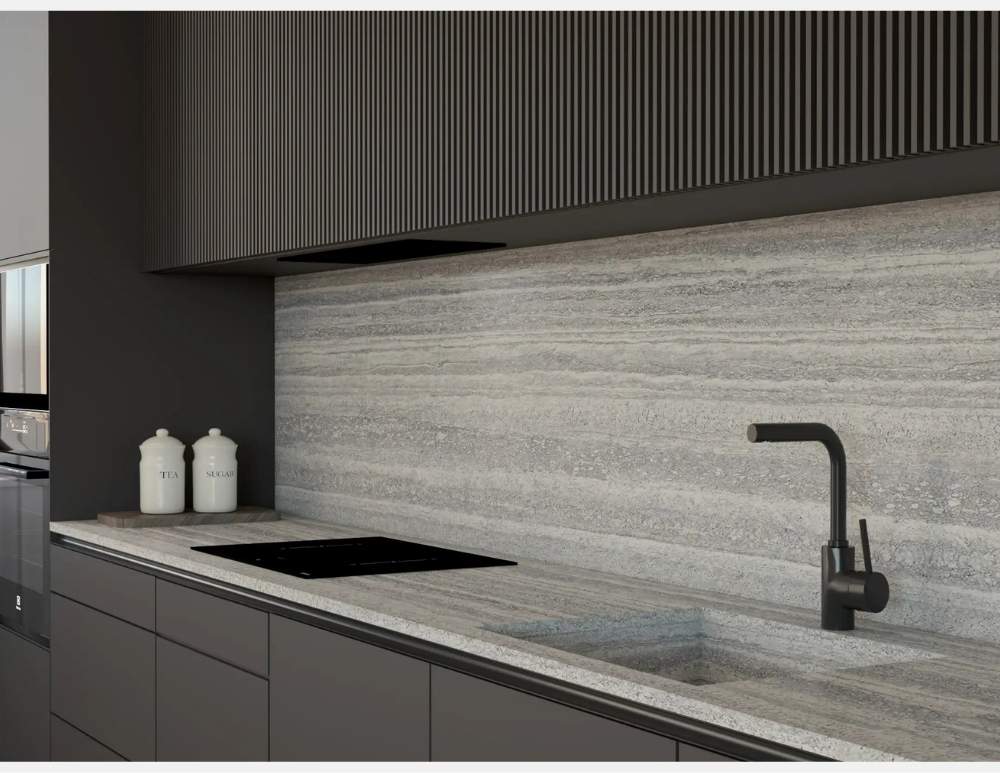 Porównanie blatów kuchennych premium SiQuartz vs. marmur, który blat zachwyci luksusowym efektem TRAVERTINO Grey. blat-kuchenny-siquartz-travertino-grey-imitacja-trawertynu-grafit. Nowoczesna kuchnia w kolorze ciemnoszarym. Blat i panel ścienny z konglomeratu kwarcowego SiQuartz w wzorze TRAVERTINO Grey, Blat kuchenny imitujący trawertyn. Konglomerat kwarcowy TRAVERTINO Grey opinie. Kuchnia w kolorze grafitowym z jasnym blatem. Blat kwarcowy odporny na uszkodzenia